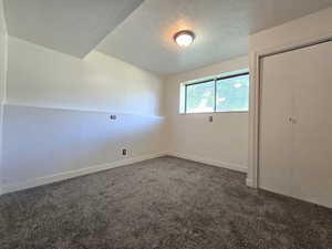 Unfurnished bedroom with carpet floors, a textured ceiling, baseboards, and a closet