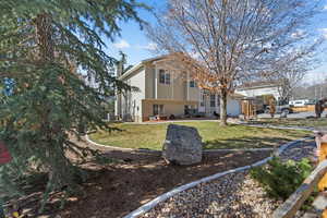 View of side of property featuring a lawn, a chimney, a garage, and brick siding
