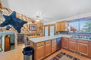Kitchen with light countertops, stainless steel dishwasher, a sink, ceiling fan, and visible vents