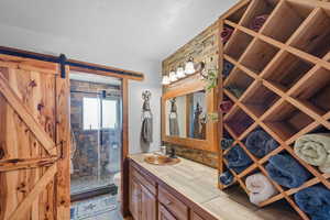 Master Bathroom with a textured ceiling, toilet, a stall shower, and vanity