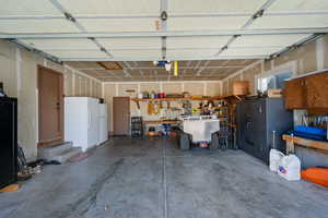Garage with a garage door opener and freestanding refrigerator