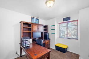 Bedroom/Home office with baseboards and carpet