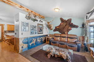 Living area featuring light wood-style flooring, vaulted ceiling, and visible vents