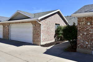 View of home's exterior with brick siding, a 2 car garage