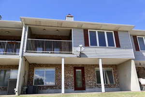 Back of property featuring a balcony, brick siding,