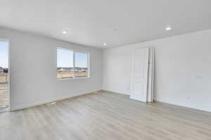 Unfurnished room featuring baseboards, recessed lighting, and light wood-style floors