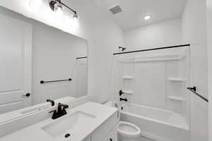 Bathroom featuring recessed lighting, shower / tub combination, vanity, toilet, and visible vents