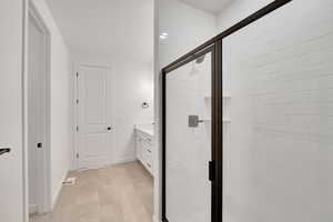 Bathroom with tile patterned flooring, a shower stall, vanity, and baseboards