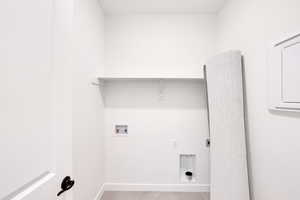 Laundry room featuring washer hookup, electric dryer hookup, baseboards, light tile patterned flooring, and laundry area