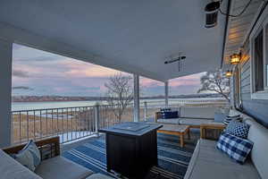 Wooden terrace with an outdoor living space and a water view