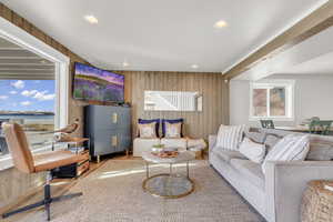 Living room featuring wooden walls, wood finished floors, and recessed lighting