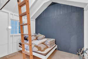 Bedroom featuring concrete flooring and lofted ceiling