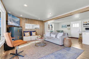 Living room featuring wooden walls, wood finished floors, and recessed lighting