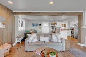 Living area featuring baseboards, light wood-style flooring, and recessed lighting
