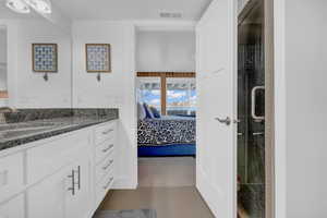 Ensuite bathroom featuring vanity, a stall shower, ensuite bathroom, and visible vents