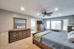 Bedroom featuring ensuite bathroom, ceiling fan, recessed lighting, and light carpet