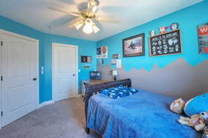 Bedroom with baseboards, ceiling fan, and carpet