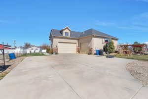 View of front of property with driveway, stucco siding, fence, and an attached garage