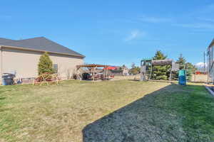 View of yard with a pergola and a playground