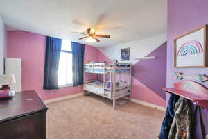 Carpeted bedroom featuring a ceiling fan and baseboards
