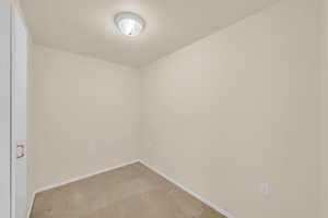 Spare room featuring light carpet and a textured ceiling