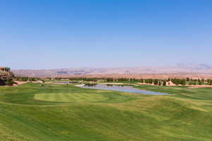 View of community featuring a water and mountain view, a yard, and golf course view