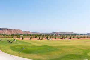 View of community with a mountain view, view of golf course, and a lawn
