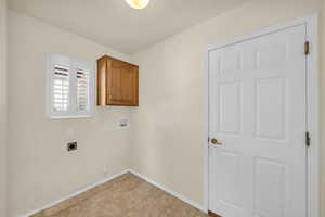 Laundry room featuring cabinet space, hookup for an electric dryer, and hookup for a washing machine