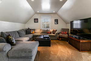 Living room with lofted ceiling, recessed lighting, and carpet