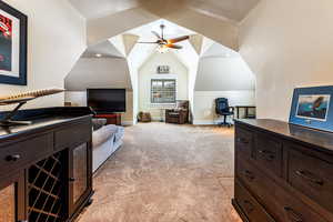 Bedroom with light carpet, baseboards, and vaulted ceiling