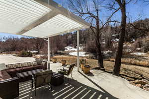 Snow covered patio featuring fence and outdoor lounge area