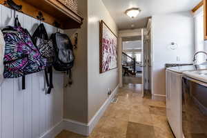 Hallway featuring light tile patterned flooring, stairway, baseboards, independent washer and dryer, and visible vents