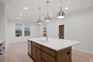 Kitchen featuring light countertops, recessed lighting, light wood-type flooring, a sink, and dishwasher