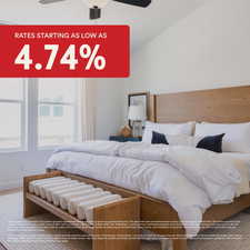 Carpeted bedroom featuring ceiling fan and vaulted ceiling
