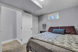 Bedroom featuring light carpet, a textured ceiling, baseboards, and visible vents