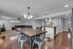 Dining space with dark wood-style floors, baseboards, and recessed lighting