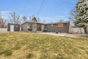 Back of house with an outdoor structure, fence, a storage shed, entry steps, and a yard