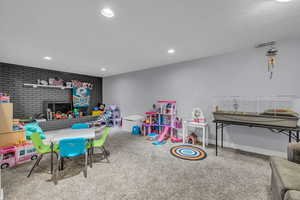 Playroom with carpet, a fireplace, baseboards, visible vents, and recessed lighting
