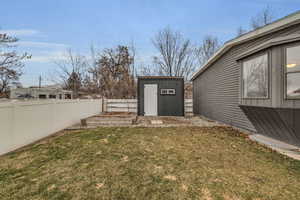 View of yard featuring a fenced backyard, an outbuilding, and a shed