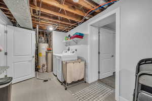 Laundry area with water heater, washer and clothes dryer, and laundry area