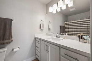 Full bath with baseboards, toilet, and vanity