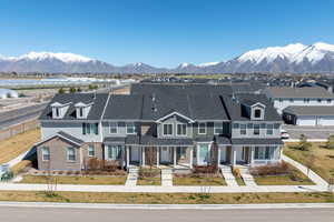 Multi unit property with brick siding, a mountain view, a shingled roof, and a residential view