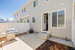 View of patio with cooling unit, area for grilling, a mountain view, and fence