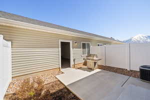 View of patio / terrace with central air condition unit, a grill, fence, and a mountain view