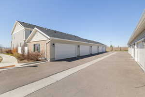 View of property exterior with community garages and brick siding