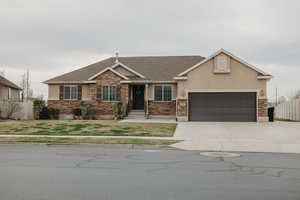 View of front of house with stucco siding, fence, and stone siding