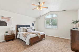 Bedroom featuring baseboards, vaulted ceiling, visible vents, and light carpet