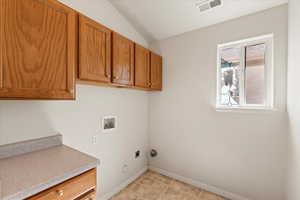 Clothes washing area featuring electric dryer hookup, cabinet space, baseboards, visible vents, and washer hookup