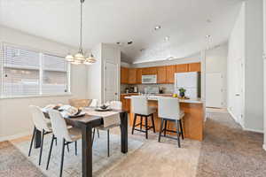Dining space with light carpet, vaulted ceiling, baseboards, recessed lighting, and a notable chandelier