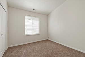 Unfurnished bedroom with a closet, visible vents, carpet flooring, and baseboards